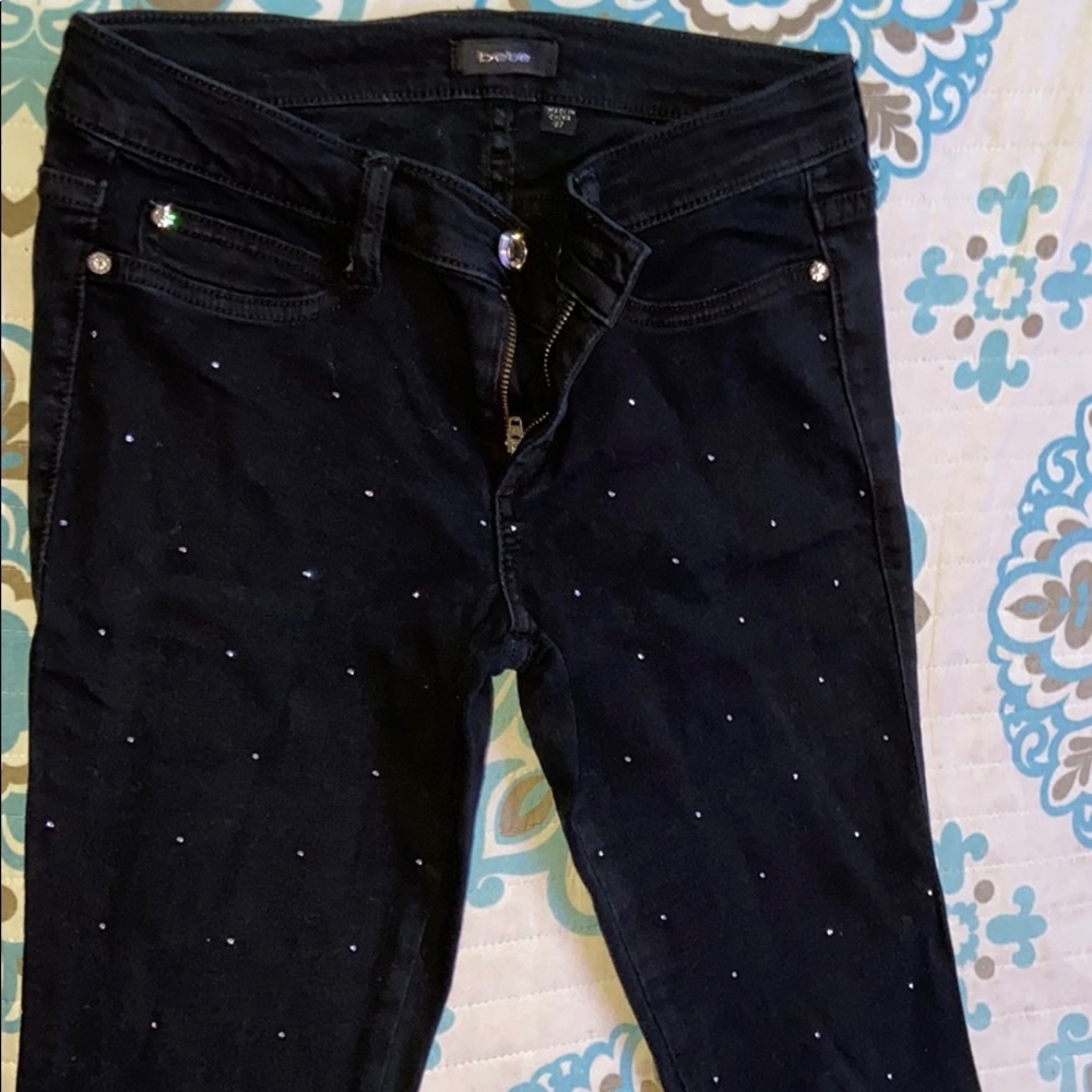 A pair of black jeans from the brand bebe,